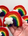 Rainbow wool cat toys with white cloud accents.