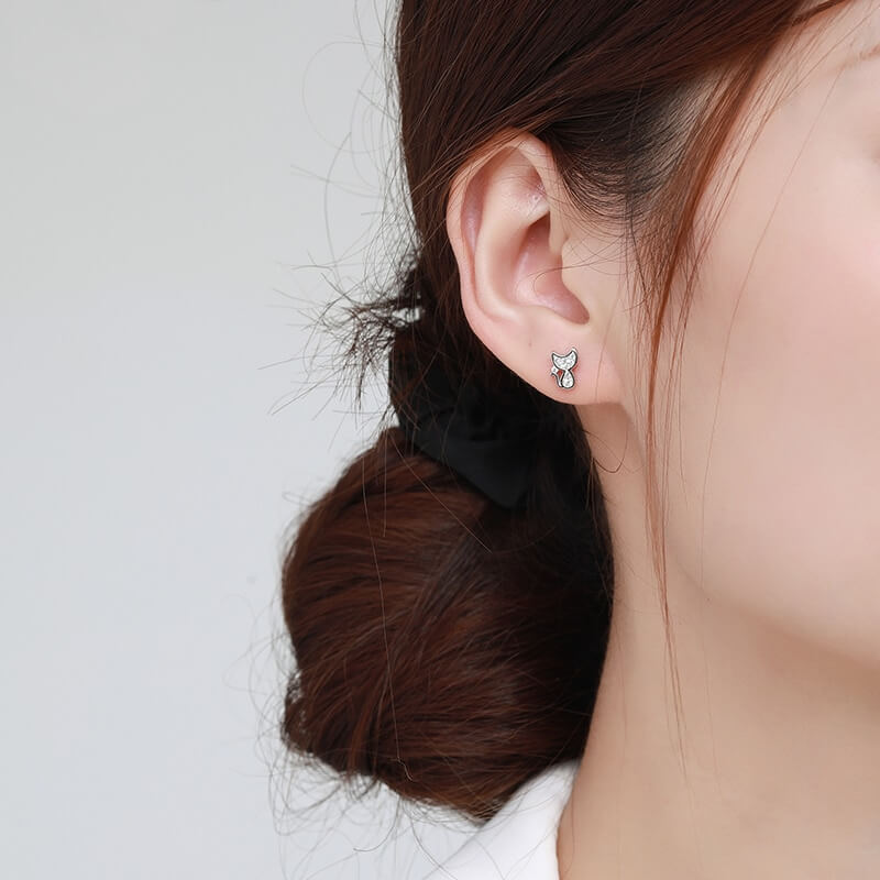 Sterling silver cat earring studs with moon shaped heads and cubic zirconia gemstones (worn by model).