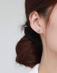 Sterling silver cat earring studs with moon shaped heads and cubic zirconia gemstones (worn by model).