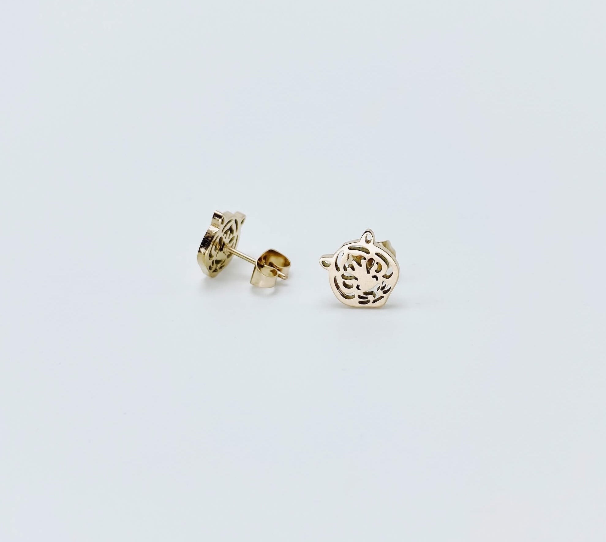 Metallic tiger stud earrings in a rose gold hue made from stainless steel. 