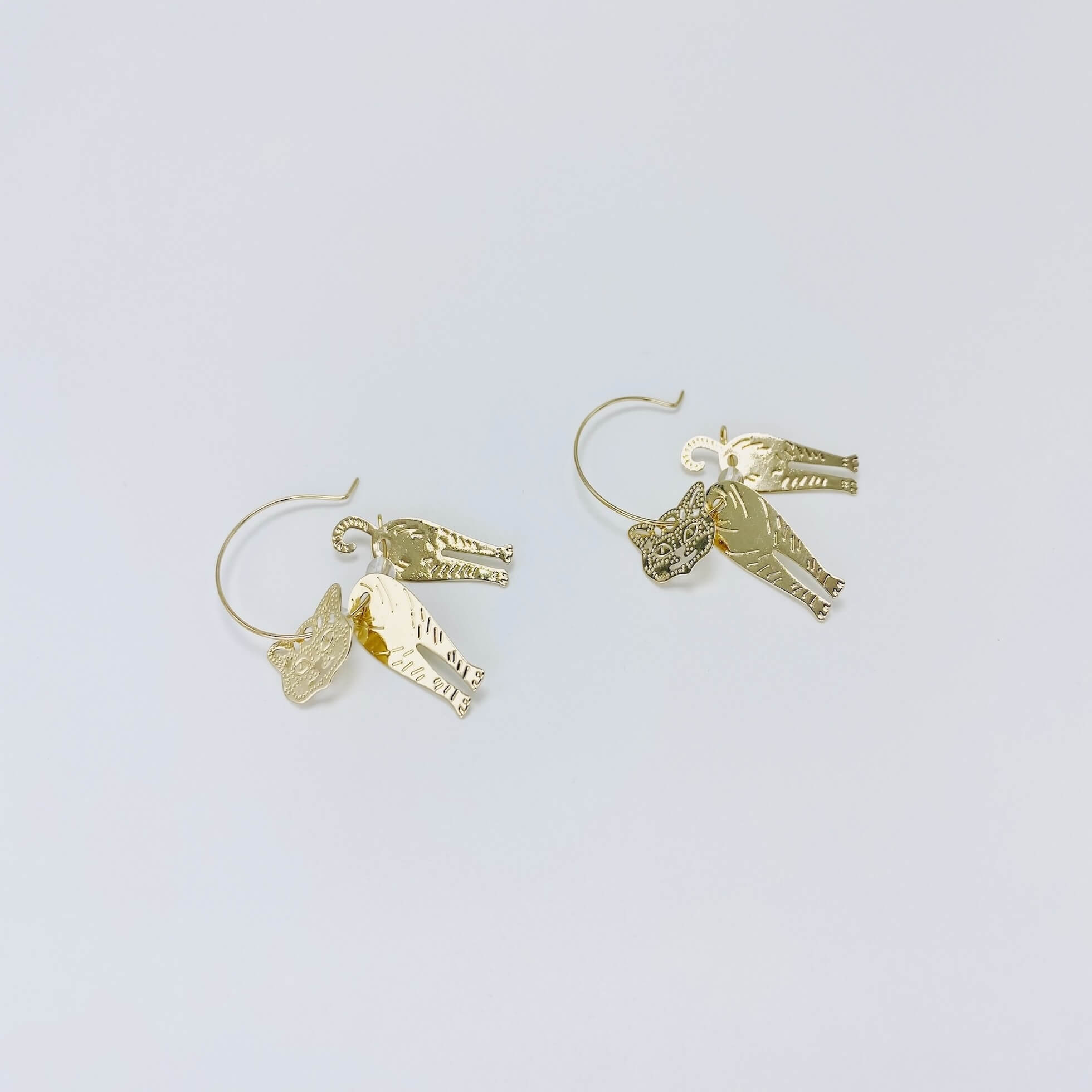 Metallic rose gold cat hoop earrings.