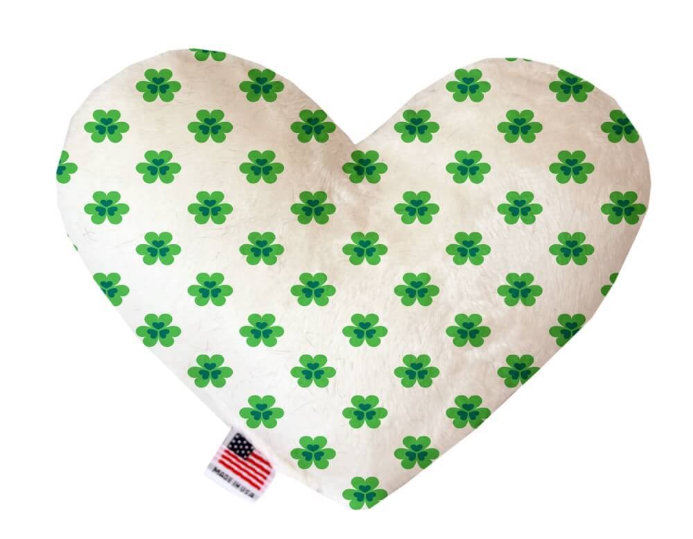 St. Patrick's Day themed heart shaped squeaker dog toy. White background with green shamrocks printed throughout. Made in USA label on bottom trim.