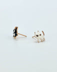 Intentionally mismatched cat stud earrings (one is black and one is white).