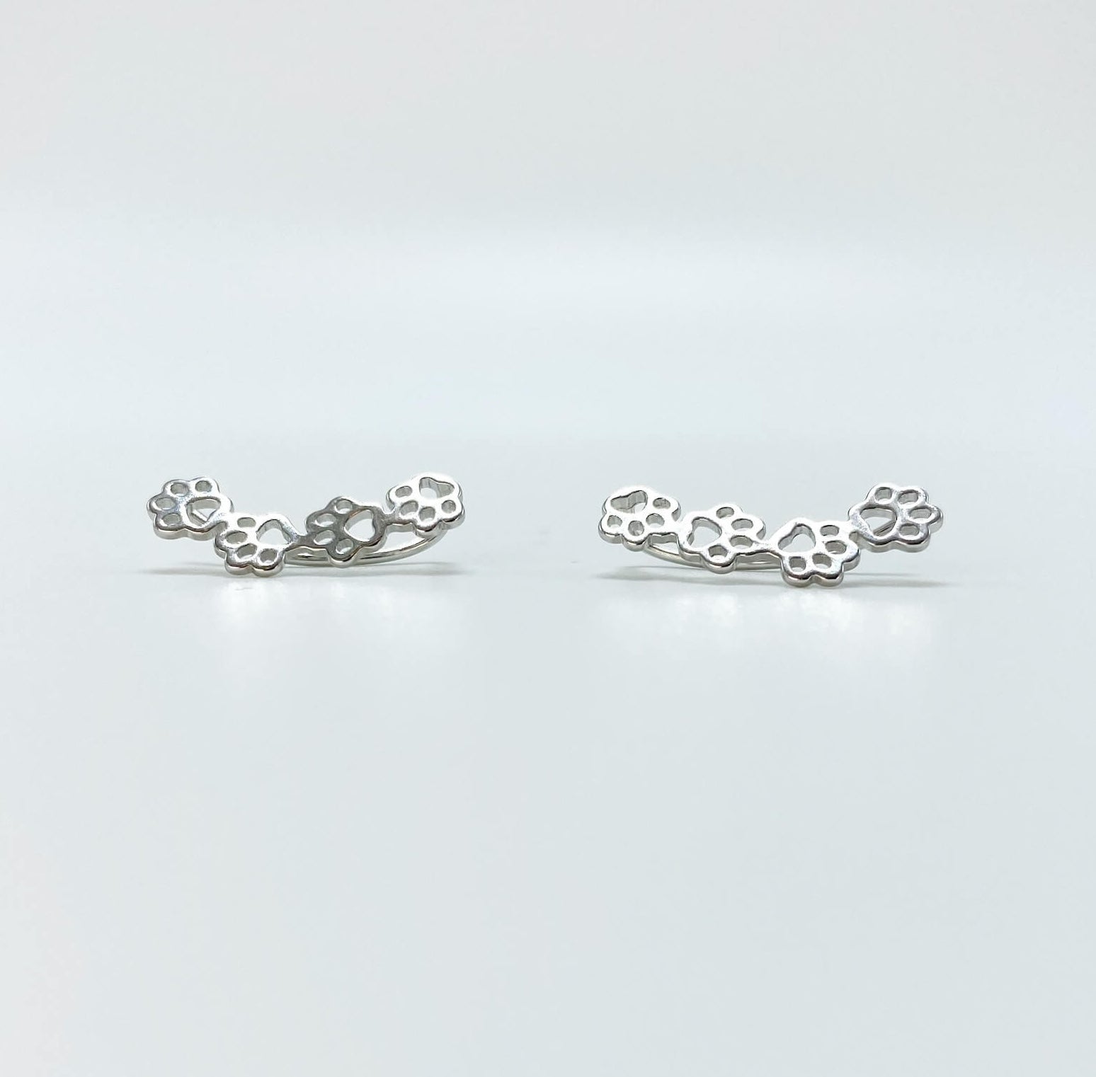 Sterling silver paw print climber earrings in silver.