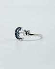 Sterling silver cat and moon ring with blue cubic zirconia gemstones in a pave setting.