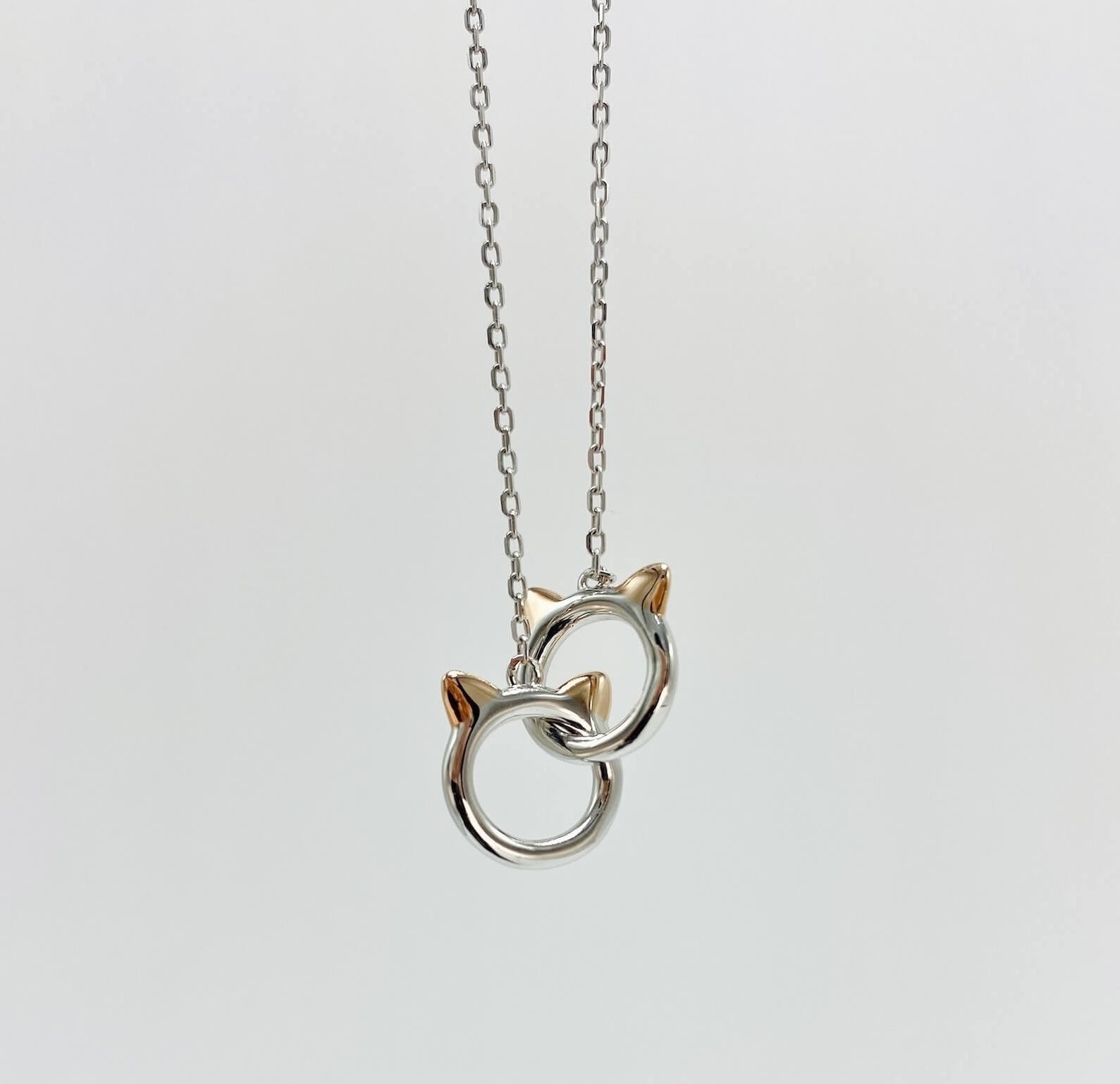 Sterling silver cat infinity necklace. Features two cat head charms that are linked. 