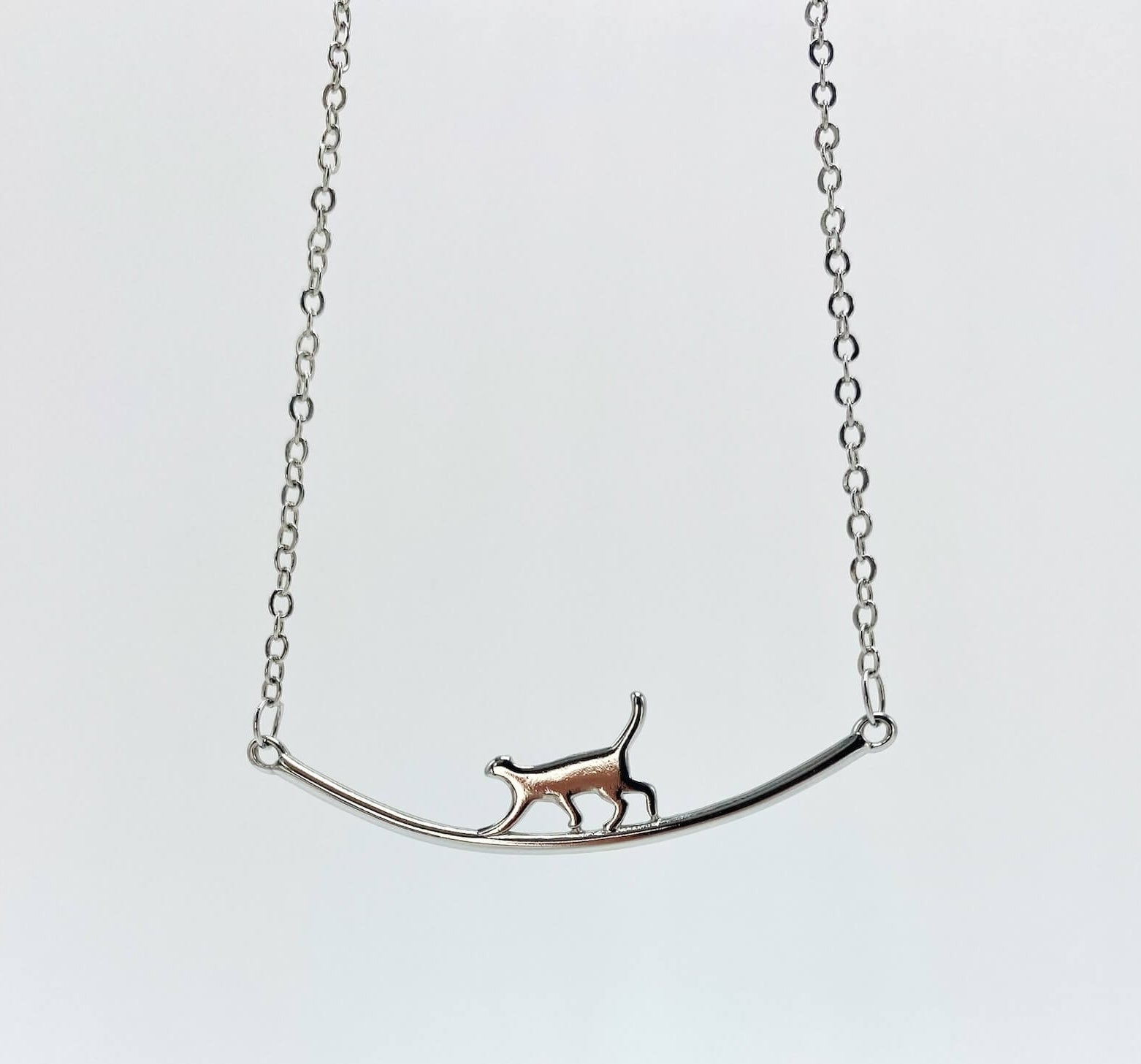 Sterling silver cat walking on bar necklace.