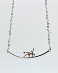 Sterling silver cat walking on bar necklace.