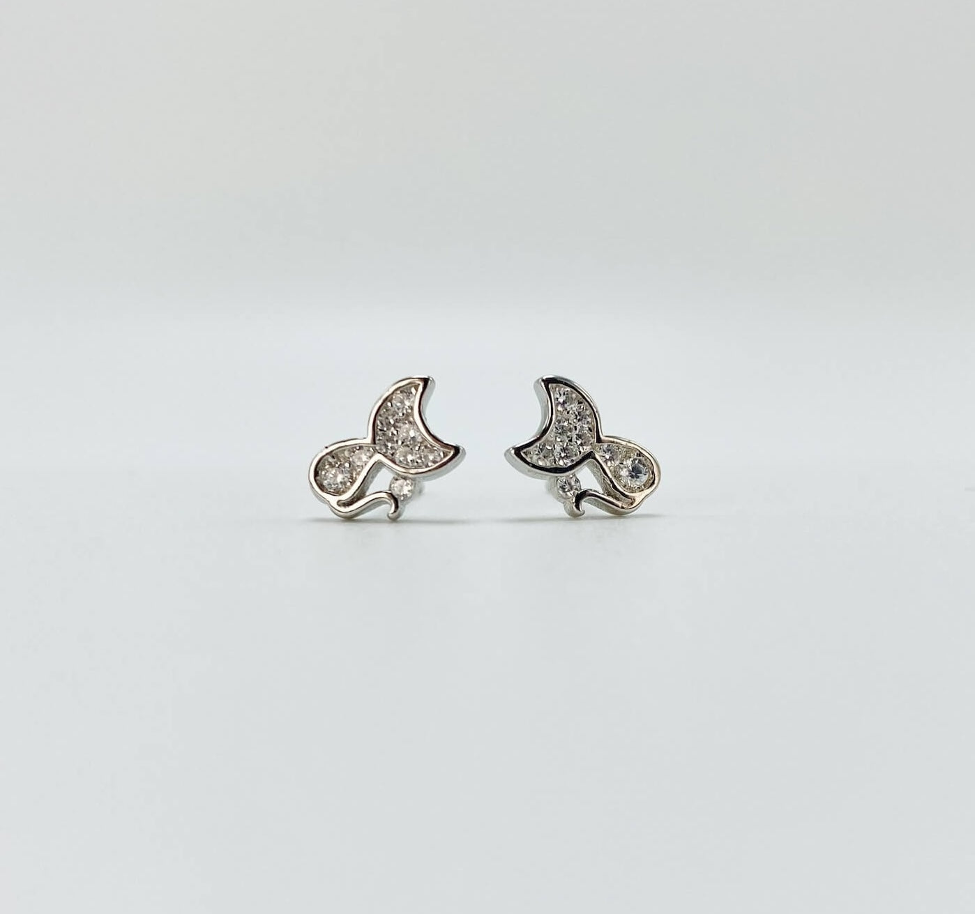 Sterling silver cat earring studs with moon shaped heads and cubic zirconia gemstones. Very small.