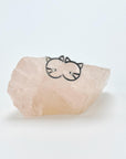Geometric half cat face sterling silver stud earrings sitting on rose quartz stone.
