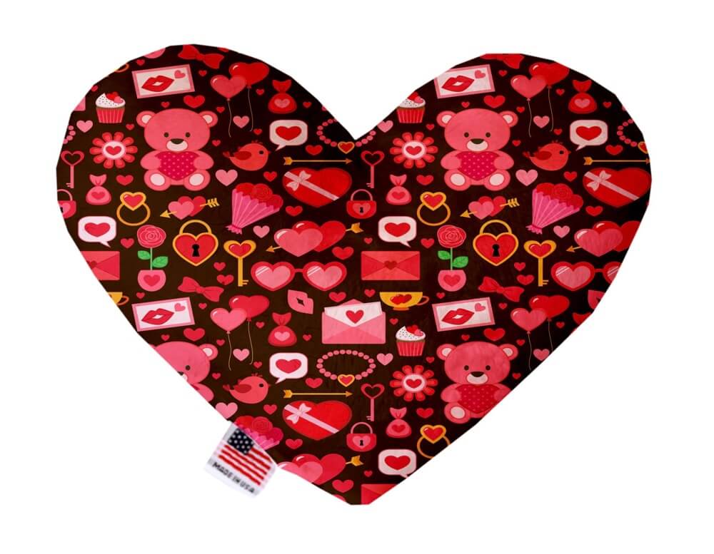 Heart shaped squeaker dog toy. Dark background with red Valentine's Day bears printed throughout. Made in USA label on bottom trim.