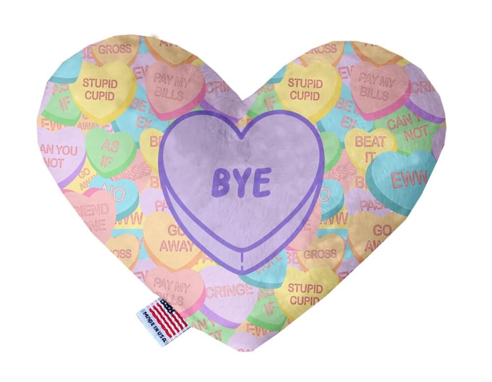 Heart shaped squeaker dog toy. Multicolored Valentine's Day candy heart background with 'Bye' heart in the center. Made in USA label on bottom trim.