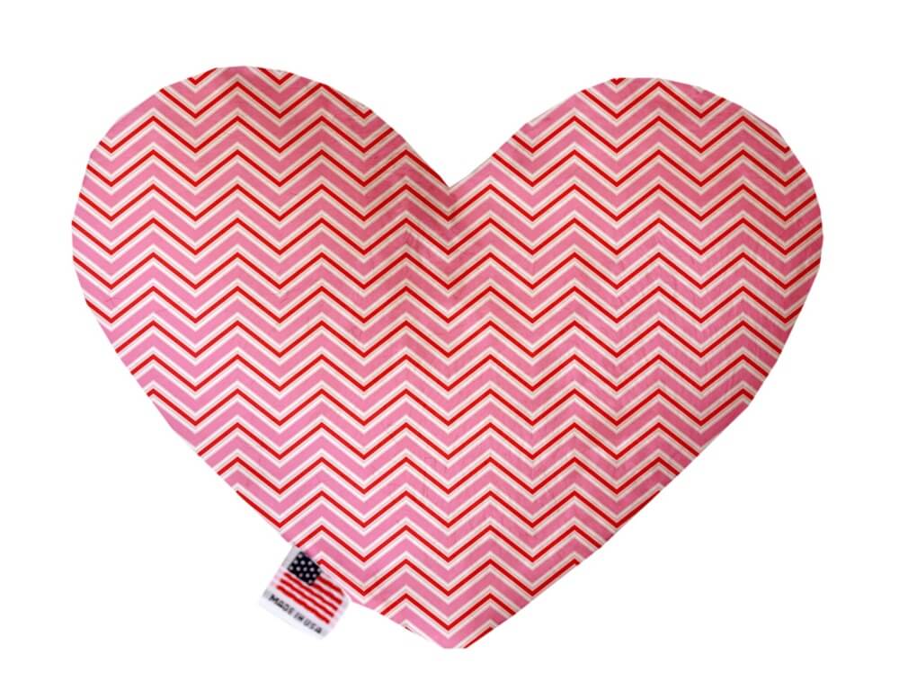 Heart shaped squeaker dog toy in pink, red and white chevron print. Made in USA label on bottom trim.