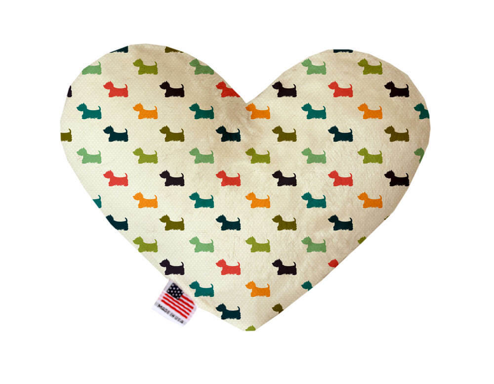 Heart shaped squeaker dog toy. Pale green background with multicolored Westies printed throughout. Made in USA label on bottom trim.